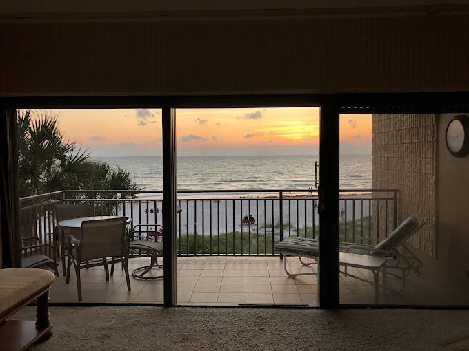 Condo balcony sliding glass doors at sunset with solar film