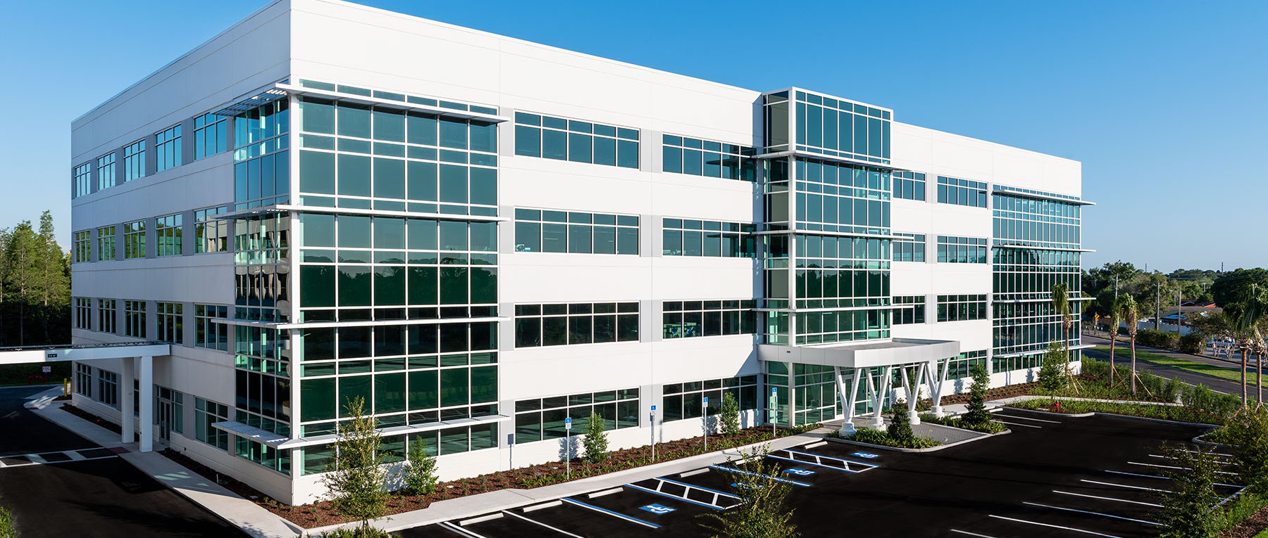 Modern white and glass commercial office building with tinted windows